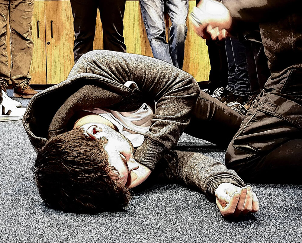 How many first aiders do I need - student practicing recovery position in first aid training class